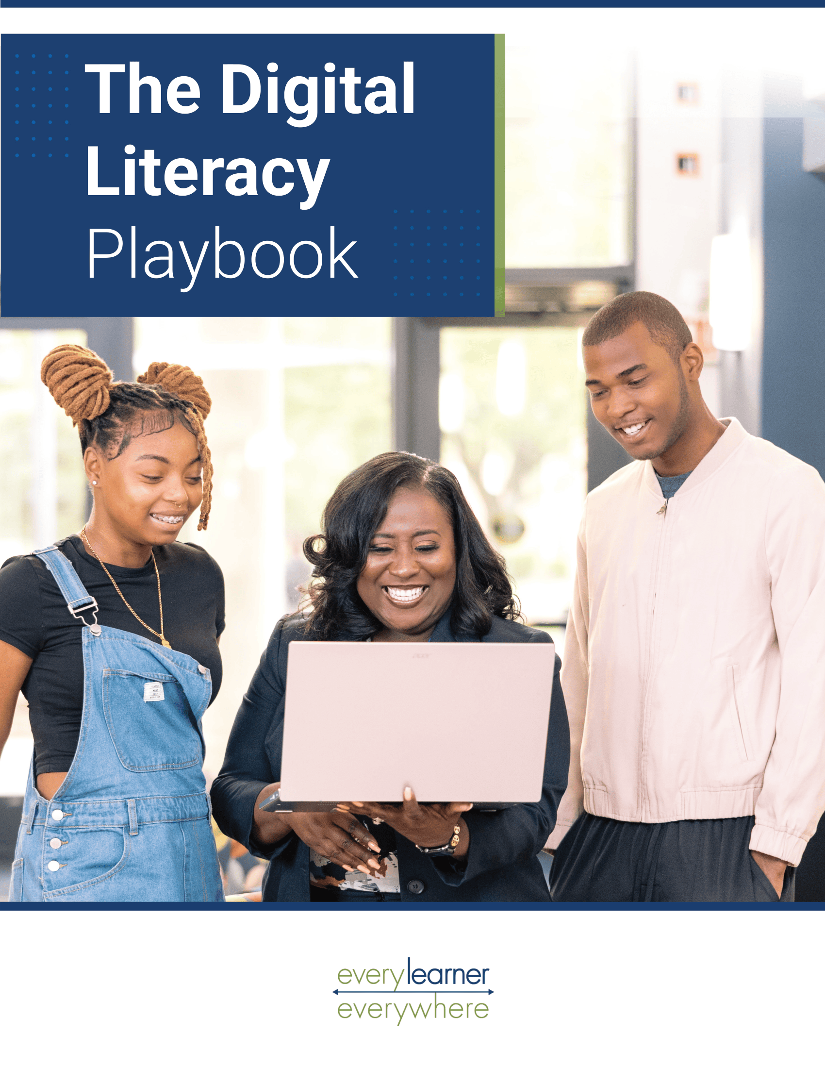 An educator stands with two students, smiling as they look at a laptop together learning digital literacy.
