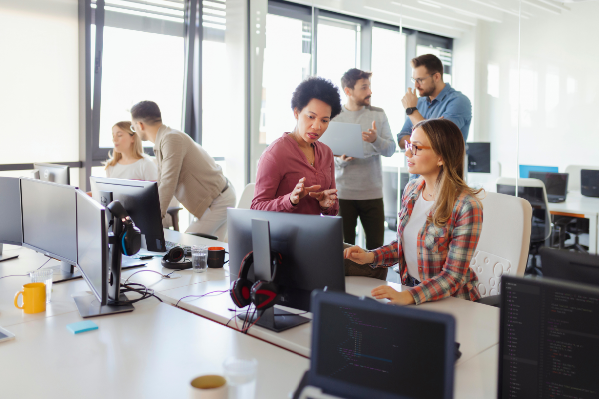 faculty on computers working together on the value of digital learning